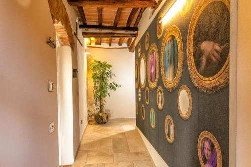a hallway with a wall with paintings on it at Palazzo Falcinelli Luxury Room in Montepulciano Center with Air Conditioning and Elevator in Montepulciano