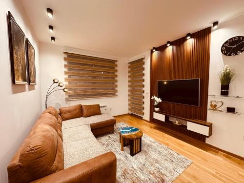 uma sala de estar com um sofá e uma televisão de ecrã plano em Snug Nest Zlatibor em Zlatibor