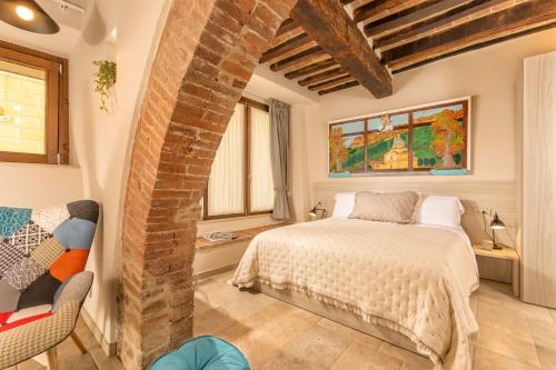 a bedroom with a bed and a brick wall at Palazzo Falcinelli Luxury Room in Montepulciano Air Conditioning and Elevator in Montepulciano