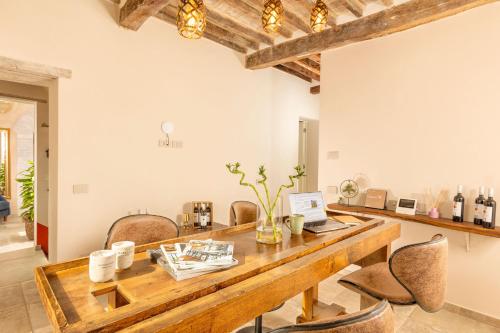 a dining room with a wooden table with chairs and a laptop at Palazzo Falcinelli Luxury Room in Montepulciano Center with Air Conditioning and Elevator in Montepulciano