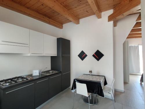 a kitchen with black and white cabinets and a table at Natur Hotel Tanca in Cardedu