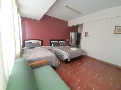 Habitación de hotel con 2 camas y sofá en Estudio Moderno! Cerca de la Plaza Principal, en Tarija