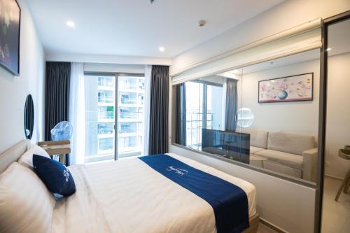 Habitación de hotel con cama y ventana grande en Căn Hộ Ban Công Hướng Biển - FREE HỒ BƠI VÔ CỰC, SAUNA, GYM, KARAOKE, BBQ - The Sóng Vũng Tàu !, en Vung Tau