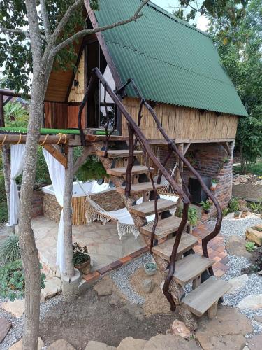 una casa sull'albero con una scala a chiocciola di fronte ad essa di Glamping el nido a Curití