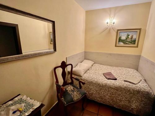 a small bedroom with a bed and a mirror at Hotel Rural Vilaflor Self check in 24h in Vilaflor