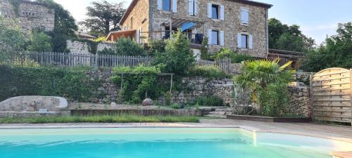 une maison avec piscine devant un immeuble dans l'établissement Gîtes Domaine De Silhac Ardèche, à Silhac