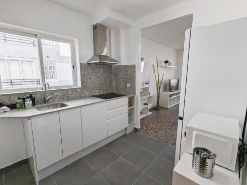 uma cozinha com armários brancos e uma janela em Apartamento Oxford II Gran Playa em Benicàssim