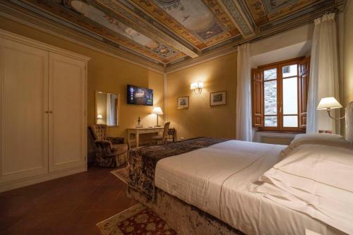 a bedroom with a bed with a coffered ceiling at Hotel Palazzo San Niccolò & Spa in Radda in Chianti