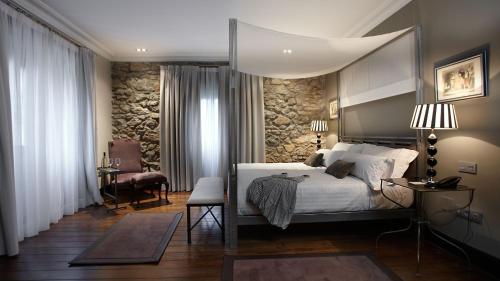 a bedroom with a bed and a stone wall at Iriarte Jauregia in Bidania-Goiatz