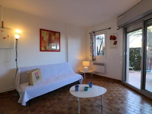 uma sala de estar com um sofá branco e duas mesas em Appartement Saint-Cyprien, 2 pièces, 4 personnes - FR-1-753-19 em Saint-Cyprien