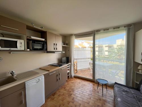 a kitchen with a large sliding glass door to a patio at Studio Saint-Cyprien, 1 pièce, 4 personnes - FR-1-753-15 in Saint-Cyprien