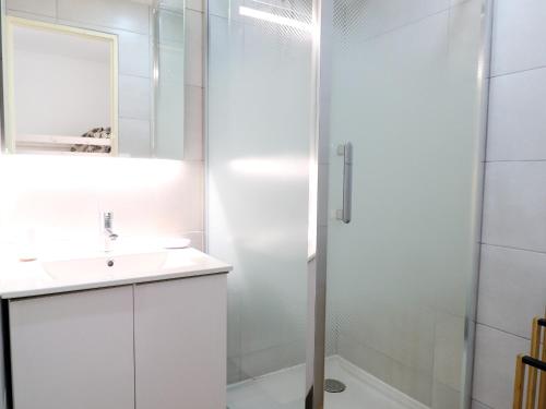 une salle de bain blanche avec une douche et un lavabo dans l'établissement Studio cabine climatisé avec piscine et parking, accès direct à la plage - FR-1-753-17, à Saint-Cyprien