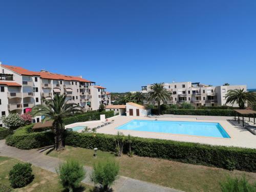 une image d'une piscine en face de certains bâtiments dans l'établissement Studio cabine climatisé avec piscine et parking, accès direct à la plage - FR-1-753-17, à Saint-Cyprien