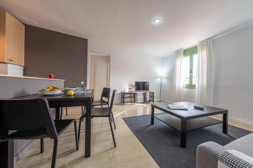 a kitchen and a living room with a table and chairs at URBAN Center Apartments in Tarragona