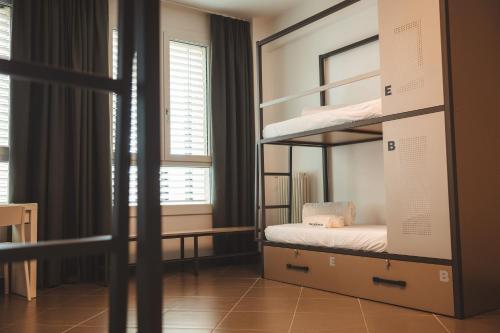 1 dormitorio con literas y ventana en Lecco Hostel & Rooms en Lecco