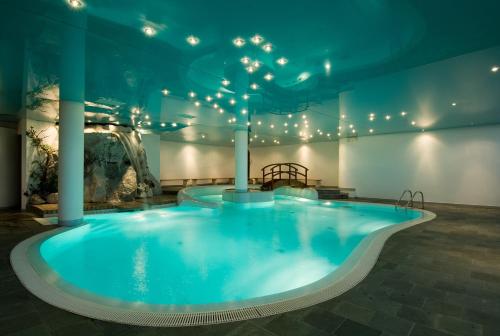 a large swimming pool with lights in a building at Residence Peniè in San Vito di Cadore