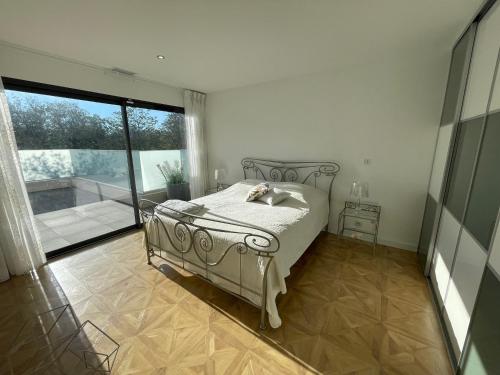 une chambre avec un lit et une grande fenêtre dans l'établissement Superbe villa contemporaine avec piscine et climatisation - FR-1-776-82, à Argelès-sur-Mer