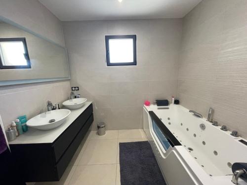 une salle de bain avec deux lavabos et une baignoire dans l'établissement Superbe villa contemporaine avec piscine et climatisation - FR-1-776-82, à Argelès-sur-Mer