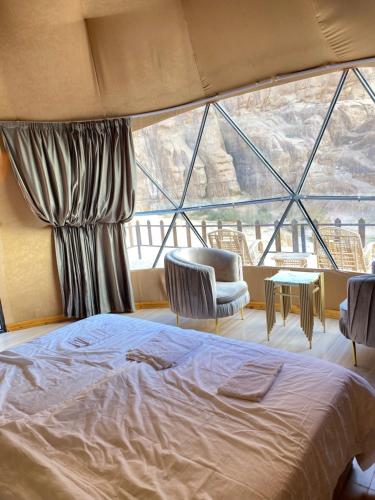 - une chambre avec un lit et une grande fenêtre dans l'établissement Hilton Wadi rum, à Disah