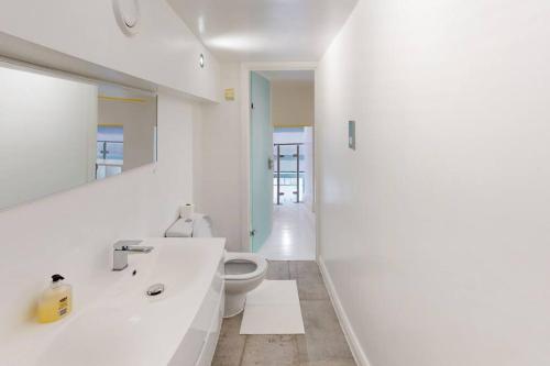 a white bathroom with a toilet and a sink at Sleeps up to 4 - City Centre in Nottingham