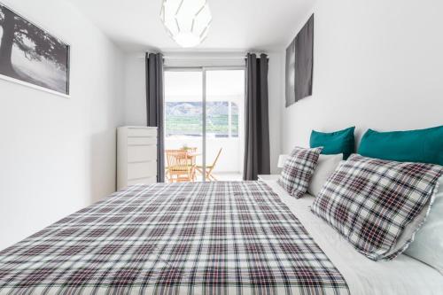 a bedroom with a bed with a plaid blanket at Apartamento Fabi in Puerto Naos