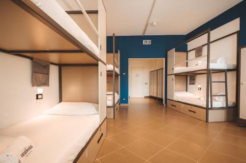 a dorm room with two bunk beds and blue walls at Lecco Hostel & Rooms in Lecco