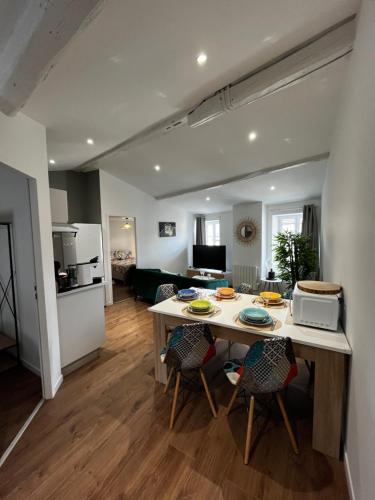 une cuisine et un salon avec une table et des chaises dans l'établissement La maison castelpontine T4, à Pont-du-Château