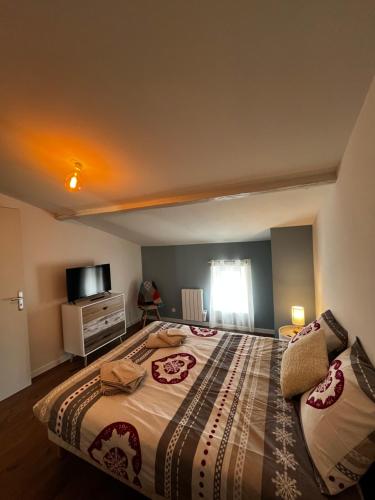 um quarto com uma cama grande e uma televisão em La maison castelpontine T4 em Pont-du-Château