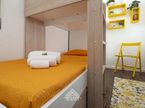 una camera con letto a castello, lenzuola gialle e sedia di Villa Laura - MORADA a SantʼAndrea