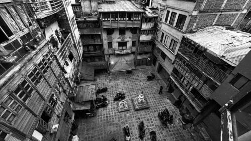 een zwart-witte foto van een straat met gebouwen bij The Pigeon Homestay Apartments in Kathmandu
