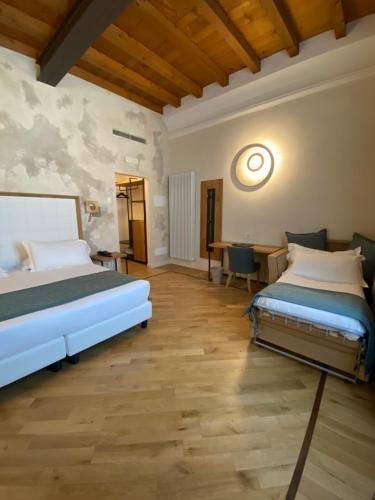 a bedroom with two beds and a desk at Cà Uberti Home Boutique in Mantova
