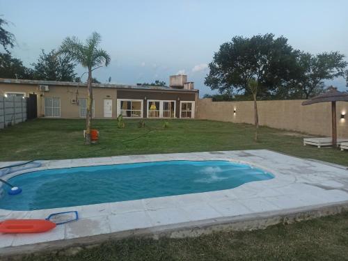 Quinta La Balbina في كورينتس: حديقه خلفيه بها مسبح ومنزل