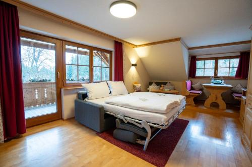 ein Schlafzimmer mit einem Bett in einem Zimmer mit Fenstern in der Unterkunft Hotel Tannenmühle in Grafenhausen