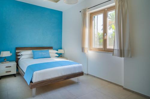 a blue bedroom with a bed and a window at Villa La Pagaia Sorrento Coast in Vico Equense