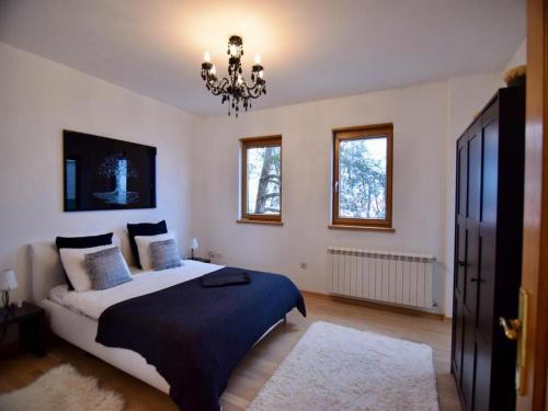 札格雷布的住宿－WOLKENHAWK，一间卧室配有一张大床和一个吊灯。