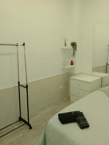 Un dormitorio con una cama con una toalla negra. en HABITACION INDIVIDUAL, en Sevilla