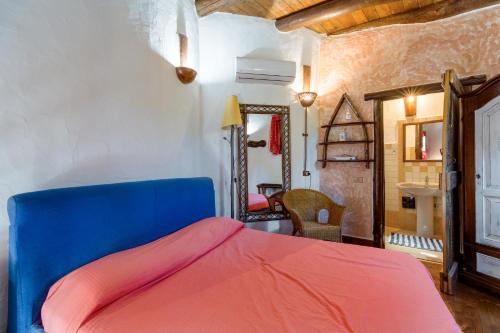 a bedroom with a blue and red bed in a room at Villa Orgoai in Orgosolo