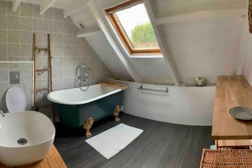 a bathroom with a bath tub and a sink at L'Olivera : entre évasion, sport et nature in Barneville-Carteret