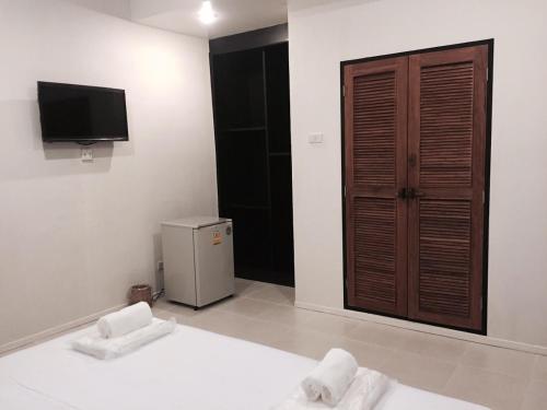 Una habitación con cama y TV y una habitación con en แอทชฎา เชียงใหม่ @Shada Chiang Mai, en Chom Thong