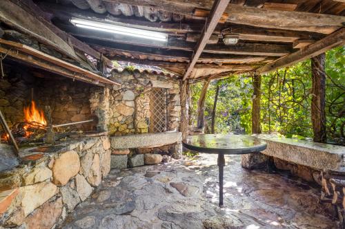 an outdoor kitchen with a table and a fireplace at Villa Orgoai in Orgosolo