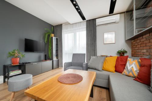 uma sala de estar com um sofá e uma mesa em Rudzka Góra Comfy Apartment em Lódź