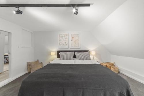 a large bed in a white room with two lights at Gut Oehe in Maasholm