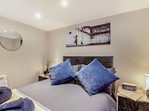 a bedroom with a bed with blue pillows at 2 Bed in Kinmel Bay 94036 in Kinmel Bay