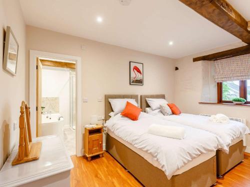 a bedroom with a large bed with orange pillows at 2 Bed in Umberleigh 88605 in Chittlehampton