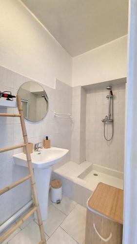 une salle de bain avec un lavabo, une baignoire et un miroir dans l'établissement Appartement lumineux, climatisé, cœur de ville., à Avignon