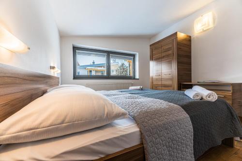a bedroom with a large bed and a window at Mountain Villas Polana in Smokovce