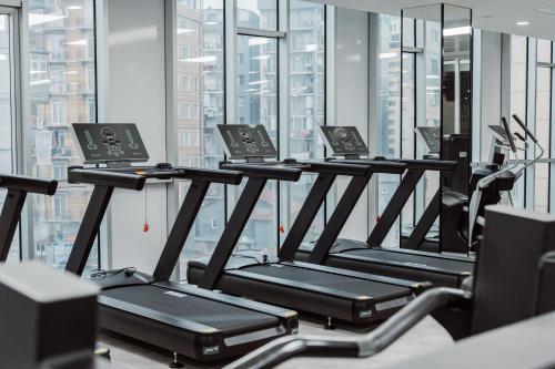 a row of treadmills in a gym with large windows at Best Western Plus Batumi in Batumi