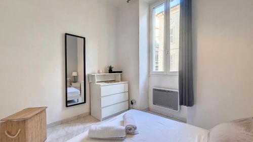 - une chambre blanche avec un miroir et un lit dans l'établissement Appartement lumineux, climatisé, cœur de ville., à Avignon