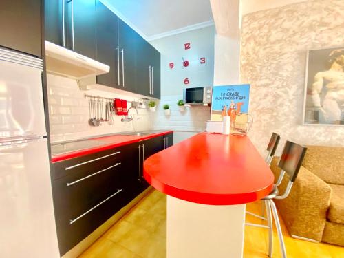 cocina con mesa roja y nevera en Wave Properties JM16 Beach, en Las Palmas de Gran Canaria