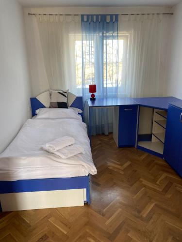 1 dormitorio con cama azul y escritorio en Astralis Factory Apartments- FLY, en Zagreb